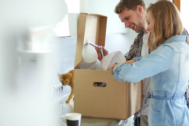 Young couple carrying big cardboard box at new home.Moving house. Young couple - Foto, imagen