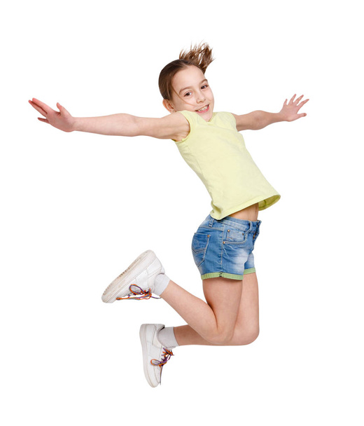 Happy teenage girl jumping on white isolated background - 写真・画像