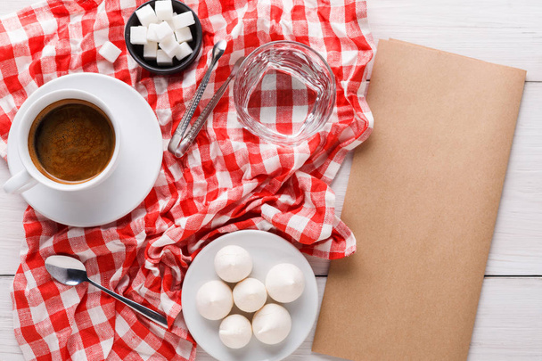 Morgenkaffee mit Leckereien auf stilvoll karierter Tischdecke auf weißem Hintergrund - Foto, Bild