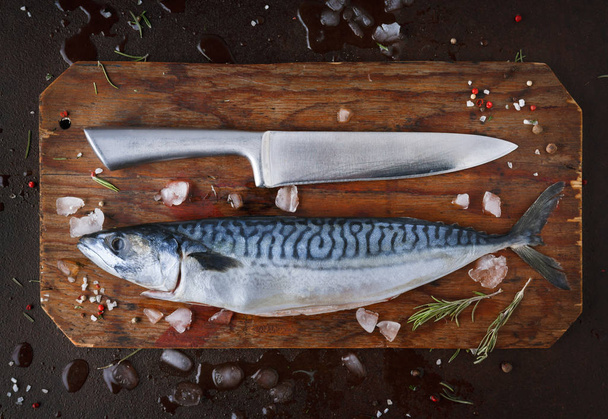 Fresh mackerel on wooden board at black background - Фото, изображение