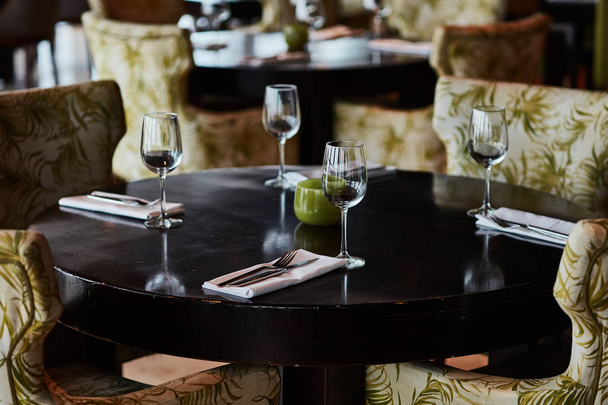 Обідній стіл подається зі склянками, виделками та ножами
 - Фото, зображення