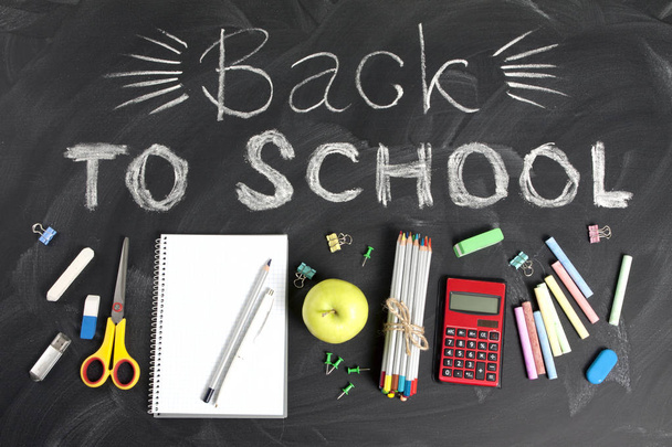 "Back to school" handwritten with school supplies on a black bac - Foto, immagini