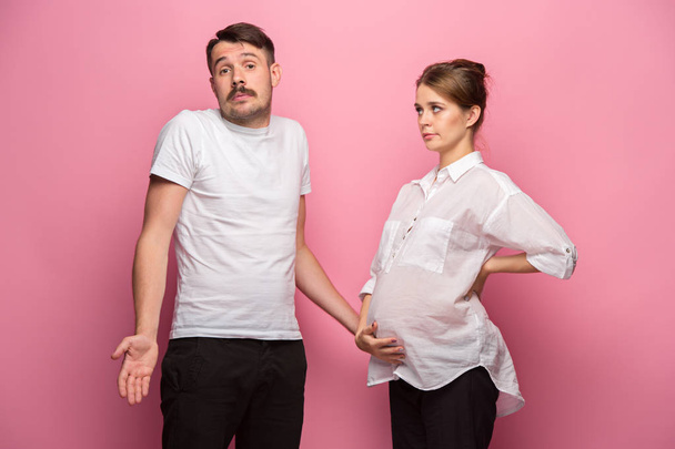 The funny surprised handsome man and his beautiful pregnant wifes tummy - Fotó, kép