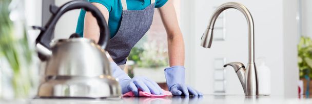Woman wiping countertop - Foto, afbeelding