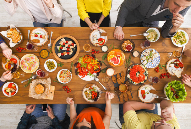 Menschen essen gesunde Mahlzeiten am gedeckten Tisch - Foto, Bild