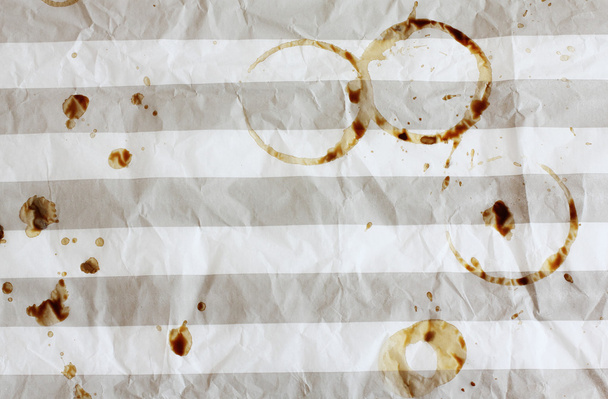 koffiekopje vlekken in verkreukelde gestreepte papier in café - Foto, afbeelding