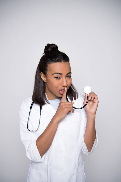 Young doctor showing silence sign. - Foto, afbeelding