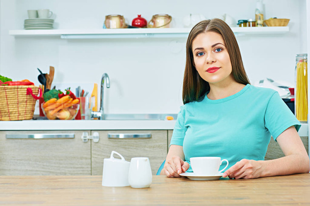 woman sitting in kitchen with coffee cup  - Фото, зображення