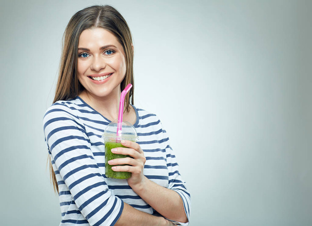 Smiling woman wearing striped holding green detox drink. - Фото, зображення