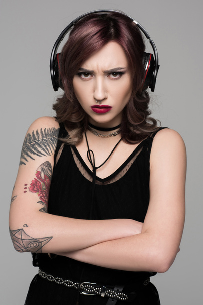 Grumpy młoda kobieta w duże słuchawki - Zdjęcie, obraz