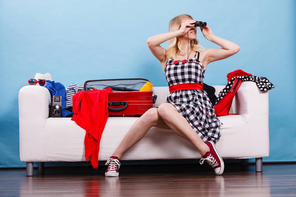 Young woman packing suitcase on couch - Foto, Bild