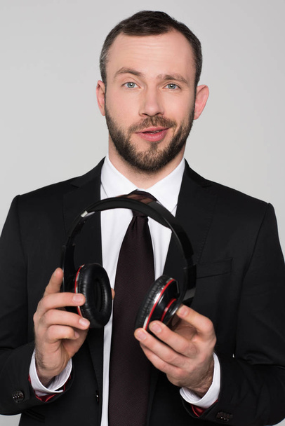  young businessman holding headphones in hands - Fotoğraf, Görsel