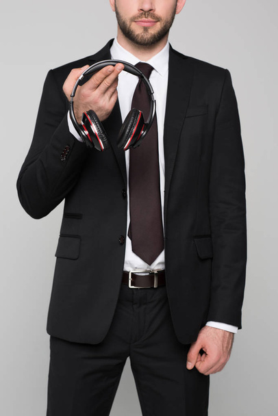 Young businessman holding headphones in hands - Fotó, kép