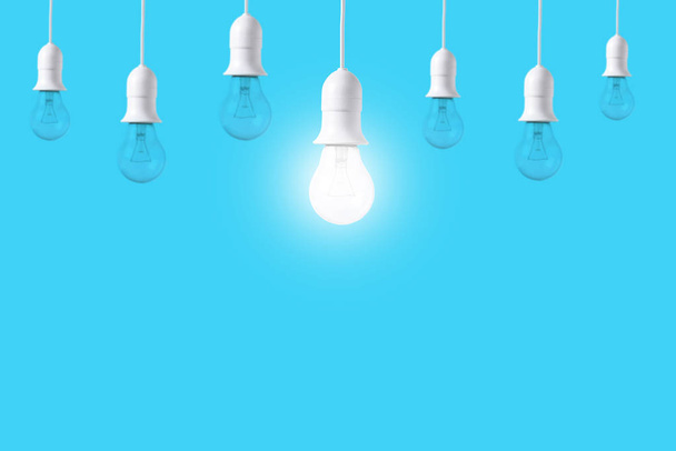 διαφορά λάμπα φωτός σε μπλε φόντο. έννοια νέων ιδεών  - Φωτογραφία, εικόνα