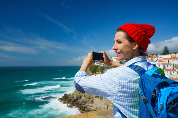 Vrouw met een rugzak maakt een foto op de smartphone van een beaut - Foto, afbeelding