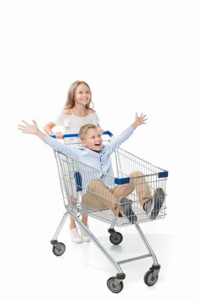 sister riding brother in shopping cart - Fotó, kép