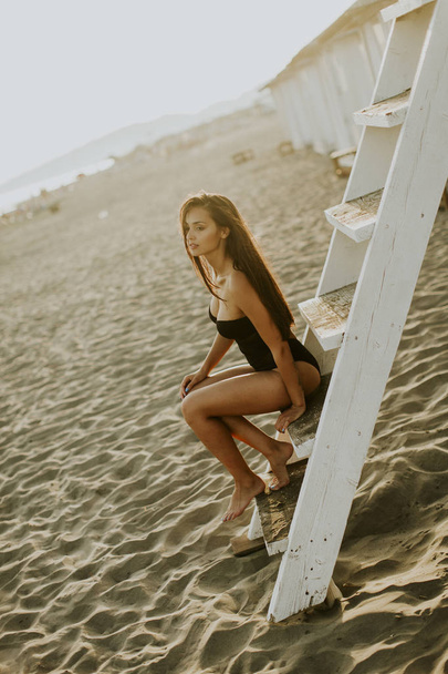 молода жінка позує на пляжі
 - Фото, зображення