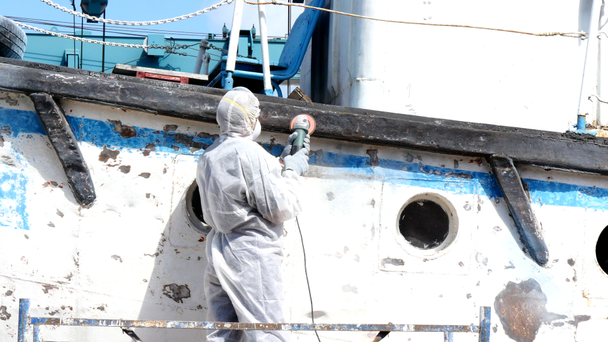 Les travailleurs arrachent la peinture sur le métal dans le processus de réparation au chantier naval
. - Séquence, vidéo