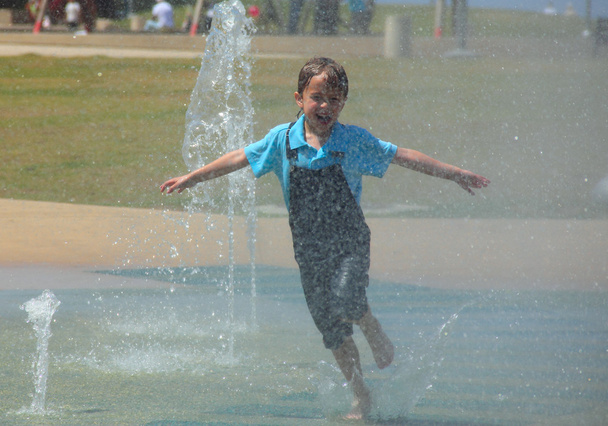 gelukkig kind baadt in een fontein - Foto, afbeelding