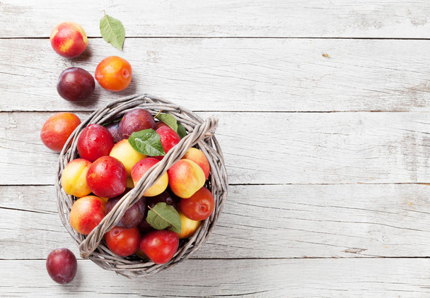 Fresh ripe plums in basket - Φωτογραφία, εικόνα