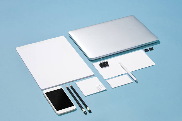 O laptop, canetas, telefone, nota com tela em branco na mesa
 - Foto, Imagem
