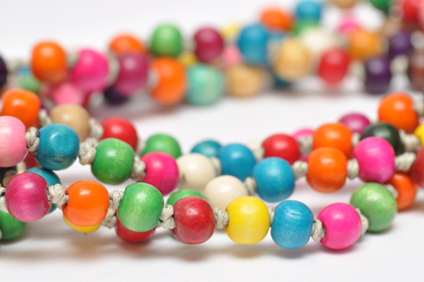 Close view of colorful wooden beads on white background - Photo, Image