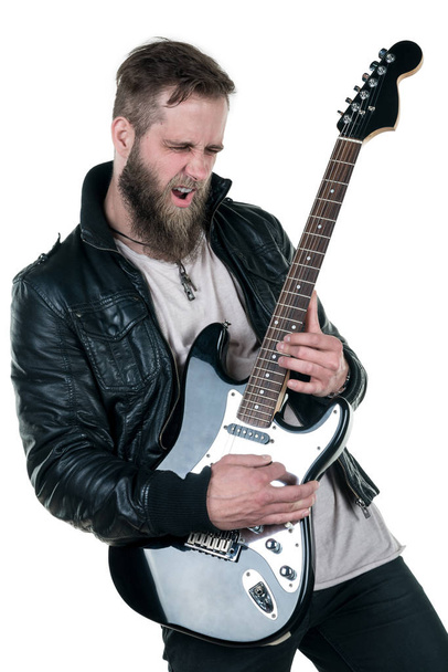 Charyzmatyczny człowiek z brodą, w skórzanej kurtce, grając na gitarze elektrycznej, na białym tle na białym tle. Ramka pozioma - Zdjęcie, obraz
