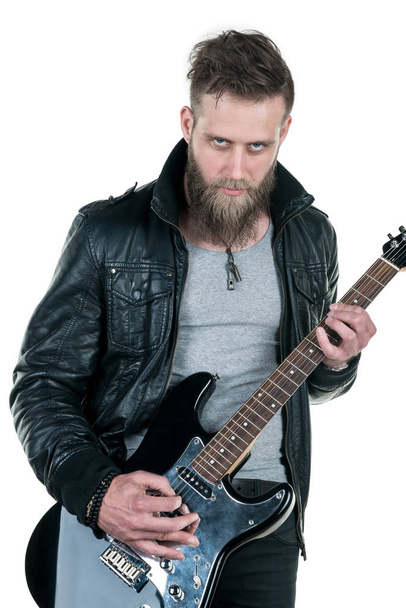 Um homem carismático com barba, de jaqueta de couro, tocando guitarra elétrica, em fundo branco e isolado. Quadro horizontal
 - Foto, Imagem