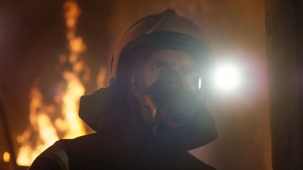 Портрет храброго пожарного, стоящего в горящем здании
.  - Фото, изображение
