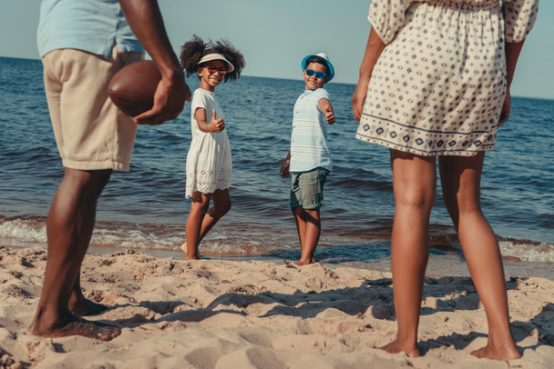 família brincando com bola na praia
  - Foto, Imagem
