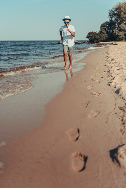 niño afroamericano corriendo en la playa
 - Foto, Imagen