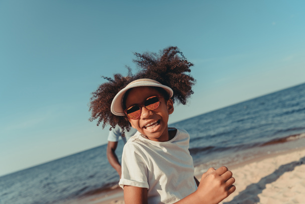 афроамериканська дитина біжить на пляжі
 - Фото, зображення
