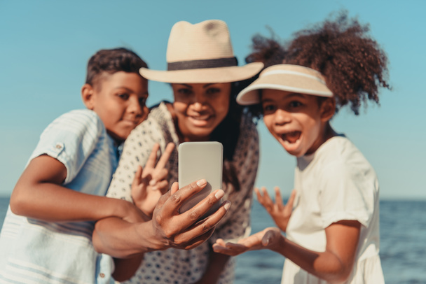 mother with kids taking selfie on beach - Photo, Image