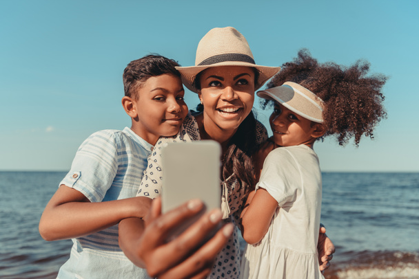 mother with kids taking selfie on beach - 写真・画像