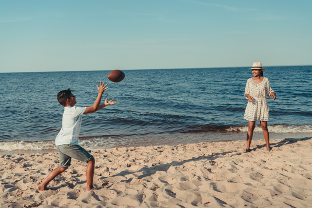 madre e hijo jugando con pelota en la playa
 - Foto, Imagen