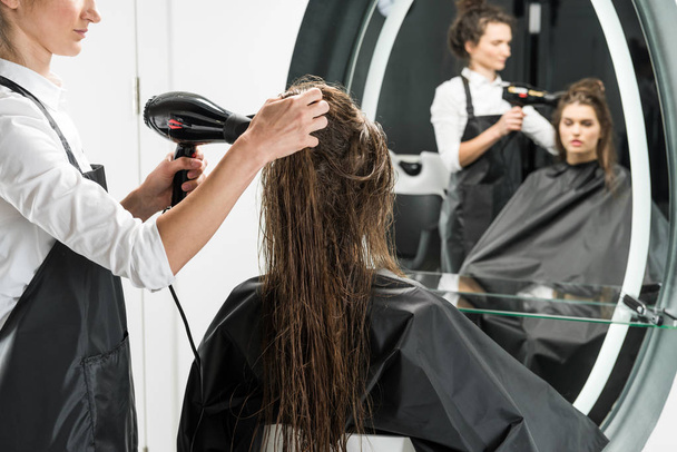 Friseur trocknet Haare der Frau - Foto, Bild
