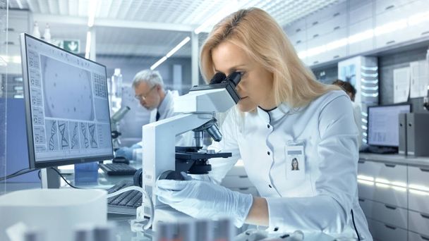 Female Research Scientist Looks at Biological Samples Under Micr - Foto, afbeelding