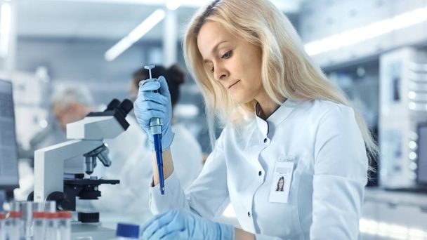 Female Research Scientist Uses Micropipette Filling Test Tubes.  - Foto, immagini