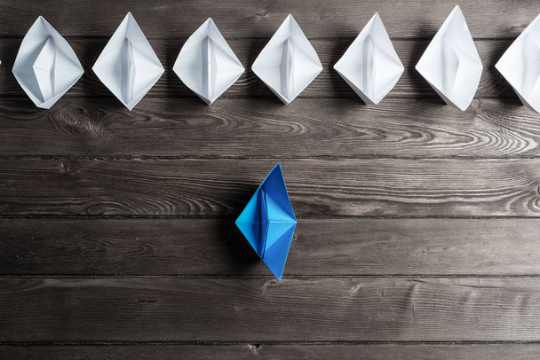 white and color paper boats on wooden table - Foto, Imagem