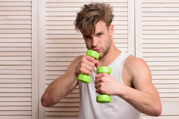 Fitness and sportive lifestyle idea. Man holds green dumbbells - Fotó, kép