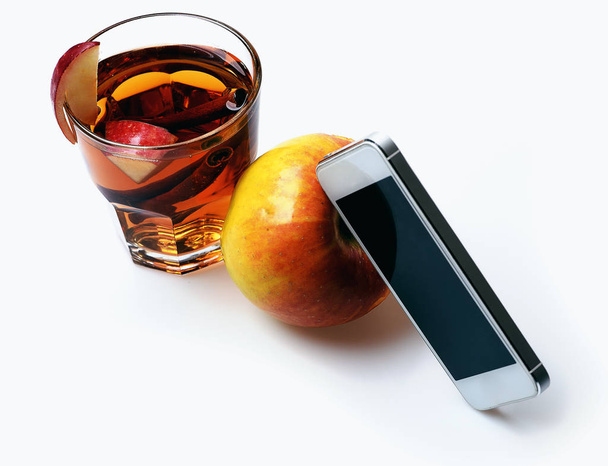 mobile phone, apple tea with cinnamon isolated on white - Fotó, kép