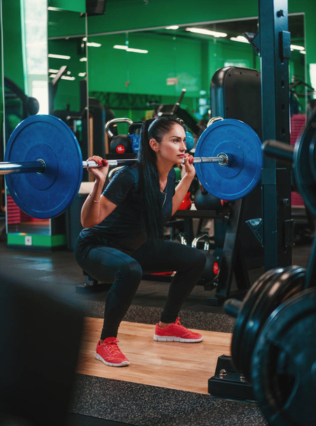 Fit femme faisant squat avec haltère dans la salle de gym
 - Photo, image