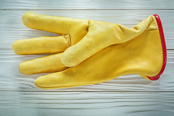 Leather safety glove on wooden board - Фото, зображення