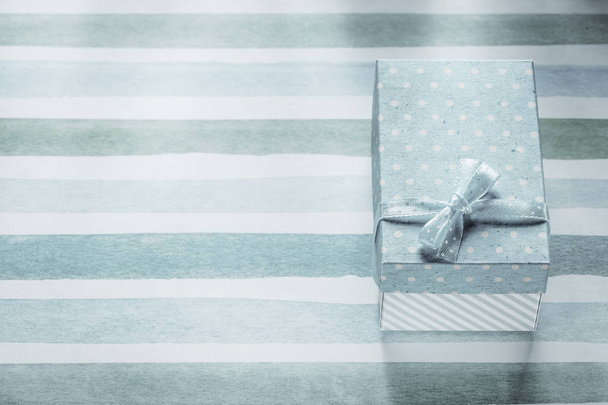 Packed present box on blue striped table cloth holidays concept - Fotó, kép
