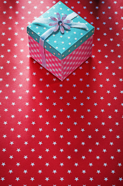 Present box on red tablecloth holidays concept - Foto, Imagen