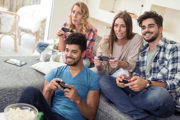 Friends playing video games at home - Photo, Image