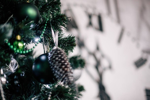 Zelený vánoční strom v pozadí je velké dekorativní hodiny ukazující midnight. - Fotografie, Obrázek