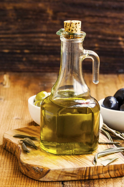 Bottiglia di olio d'oliva biologico su sfondo rustico in legno
 - Foto, immagini