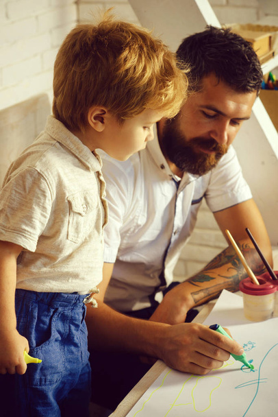 Team munka rajz, az Atya és a fiú festék együtt, apja tanítja fiát Hogyan fest a helyes és szép, a papír. Családi kreativitás és az oktatás otthon, apa, művész és fia figyelmes hallgató - Fotó, kép