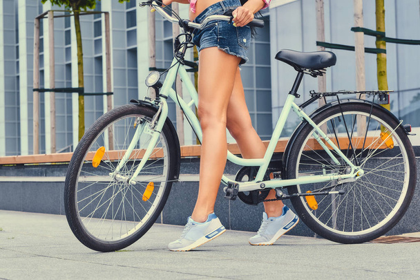 Woman's tan legs riding a bicycle  - Photo, image